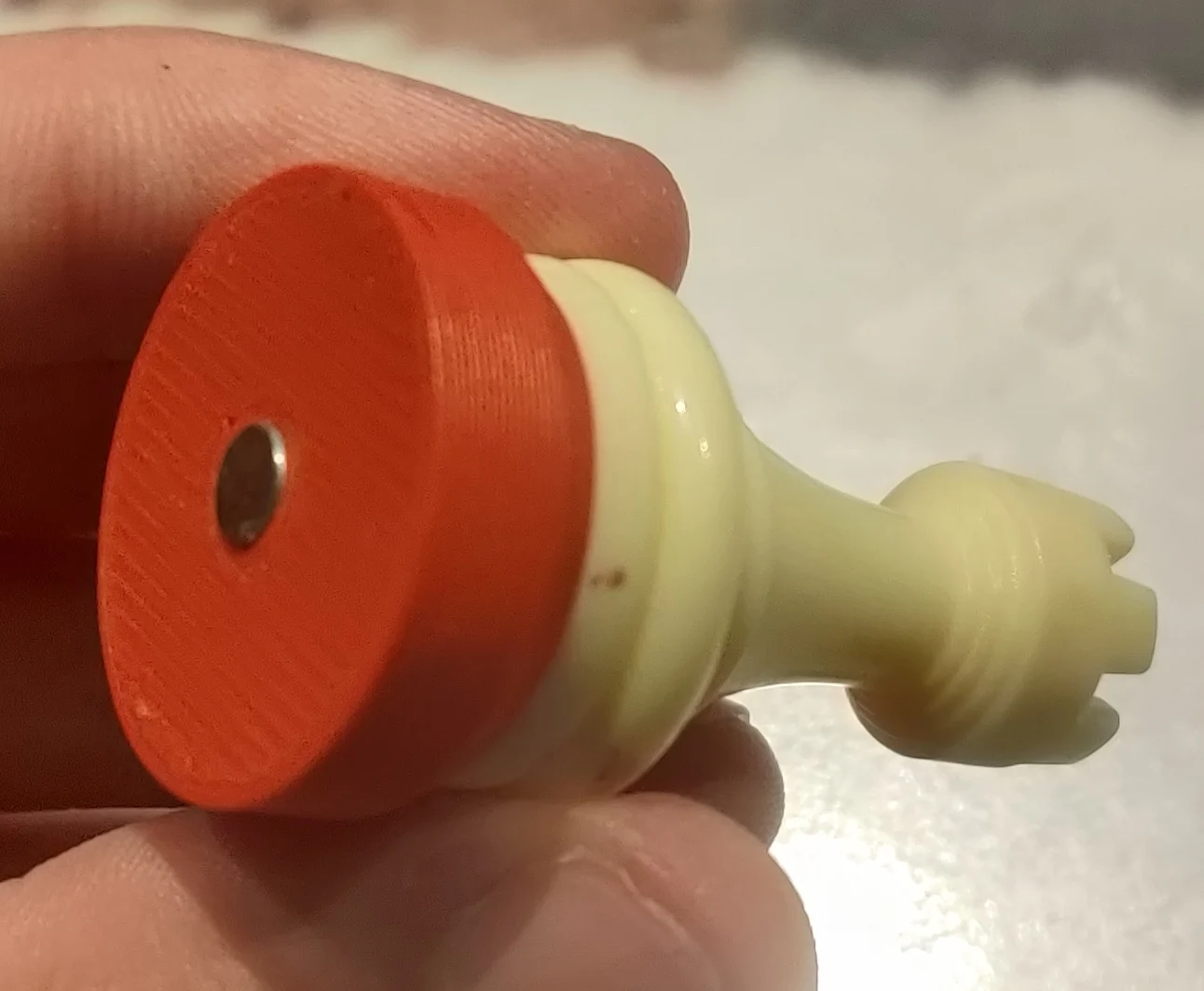 Red 3D-printed base on a chess piece holding a centered magnet
